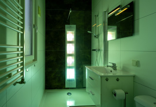 Baño moderno en Biebosch - Sunshower en Resort Mooi Bemelen, Países Bajos, con ducha y lavabo.