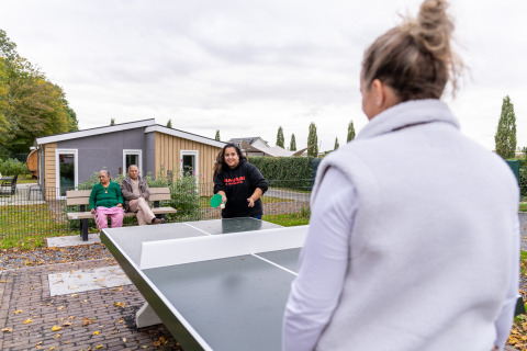 Twee vrouwen spelen buiten pingpong bij Biebosch - Sunshower op Resort Mooi Bemelen in Nederland.