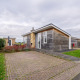 Moderne lodge Biebosch - tuinhuis op Resort Mooi Bemelen in Nederland met bestrate oprit en tuin.