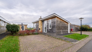 Moderne Lodge Biebosch - tuinhuis im Resort Mooi Bemelen, Niederlande, mit gepflastertem Parkplatz.