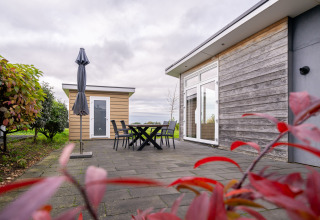 Terraza exterior en Biebosch - tuinhuis en Resort Mooi Bemelen, Países Bajos, con mesa y sillas.