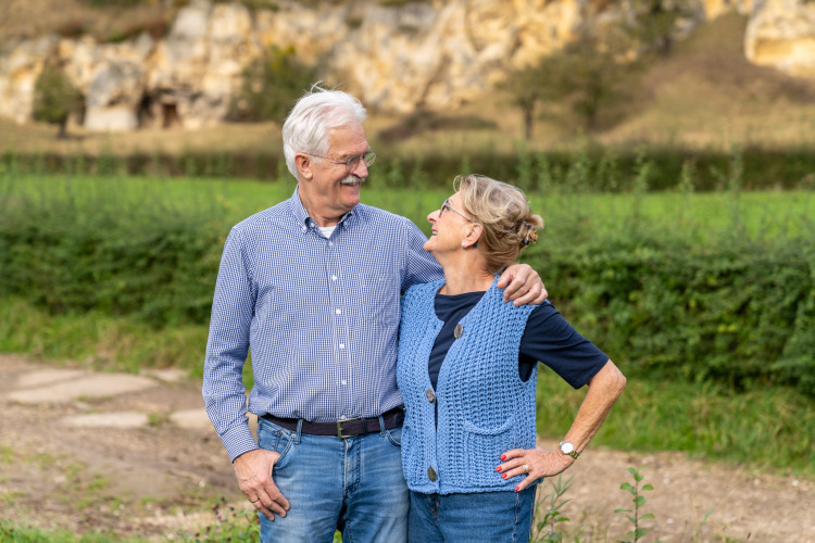 Pareja mayor sonriendo al aire libre en Biebosch - tuinhuis, Resort Mooi Bemelen, Países Bajos.