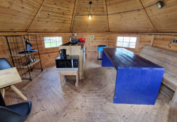 Indvendig udsigt af Tiny Wagon ved Marina Parcs Almere, Holland, med træmøbler og køkkenudstyr.
