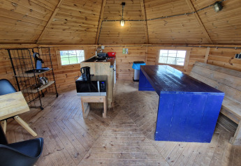 Indvendig udsigt af Tiny Wagon ved Marina Parcs Almere, Holland, med træmøbler og køkkenudstyr.