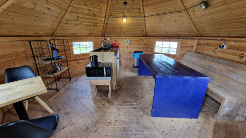 Binnenzicht van Tiny Wagon bij Marina Parcs Almere, Nederland, met houten meubels en keukengerei.