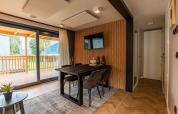 Moderne eetkamer met grote ramen en zicht op het balkon in Enzian Waterfront, Ossiacher See, Oostenrijk.