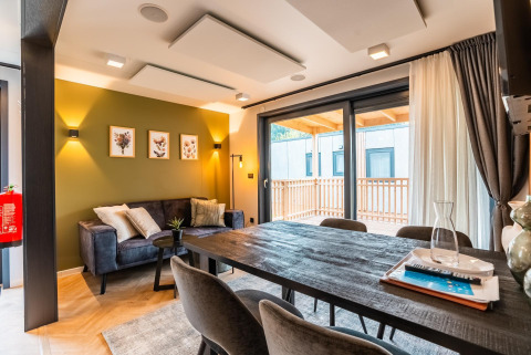 Moderna sala de estar y comedor en Enzian Waterfront Lodge junto al lago Ossiacher See, Austria, con decoración elegante.