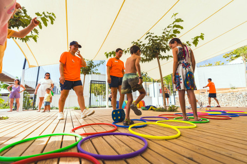 Niños juegan supervisados por adultos en la zona de juegos del Camping Costa del Sol Glamping Village.