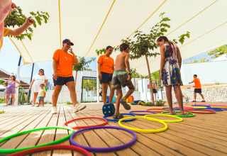 Børn leger under opsyn af voksne på legepladsen i Camping Costa del Sol Glamping Village, Andalusien.