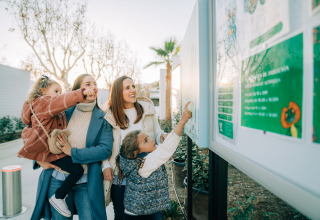 Famiglia davanti a una bacheca informativa al Camping Costa del Sol Glamping Village, Andalusia, Spagna.