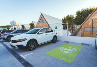 Elektrische wagen geparkeerd aan laadpunt bij Camping Costa del Sol Glamping Village, Andalusië, Spanje.