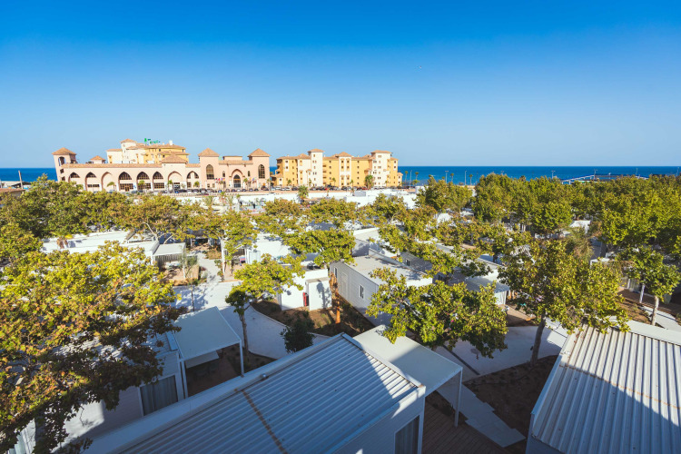 Camping Costa del Sol Glamping Village in Andalusien, Spanien, mit Hütten, Bäumen und Meerblick.