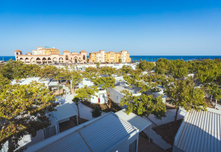 Camping Costa del Sol Glamping Village in Andalusië, Spanje, met chalets, bomen en zicht op de zee.