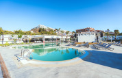 Swimmingpool og liggestole under en klar himmel ved Camping Costa del Sol Glamping Village i Andalusien, Spanien.