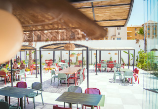 Buiteneethoek met kleurrijke stoelen en tafels bij Camping Costa del Sol Glamping Village in Andalusië, Spanje.