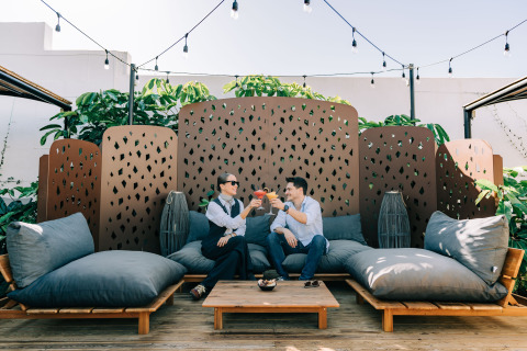 To personer nyder drinks på Camping Costa del Sol Glamping Village i Andalusien, Spanien, omgivet af planter.