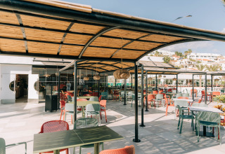 Outdoor dining area with colorful chairs at Camping Costa del Sol Glamping Village in Andalusia, Spain.