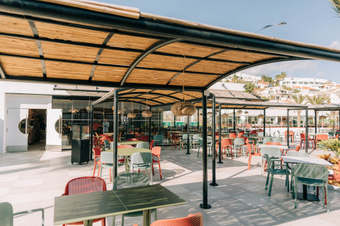 Outdoor dining area with colorful chairs at Camping Costa del Sol Glamping Village in Andalusia, Spain.