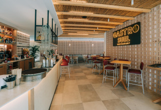 Interior of Gastro Suel Restaurant at Camping Costa del Sol with bar, wood accents and relaxed Andalusian style.