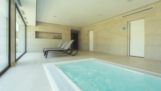 Zona de spa interior con jacuzzi y tumbonas en Camping Costa del Sol Glamping Village en Andalucía, España.