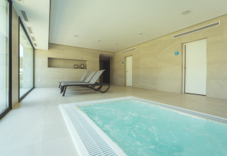 Binnenruimte met jacuzzi en ligstoelen bij Camping Costa del Sol Glamping Village in Andalusië, Spanje.