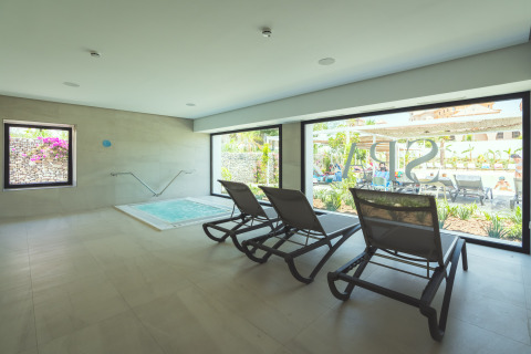Zona de relax interior con tumbonas y jacuzzi en Camping Costa del Sol Glamping Village, Andalucía, España.