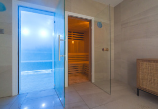 Area spa interna con porte in vetro verso sauna e bagno turco a Camping Costa del Sol Glamping Village.