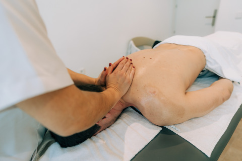 Persoon ontvangt rugmassage bij Camping Costa del Sol Glamping Village, een vakantiepark in Andalusië, Spanje.