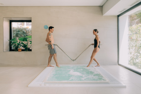 Couple enjoying indoor jacuzzi at Camping Costa del Sol Glamping Village in Andalusia, Spain.