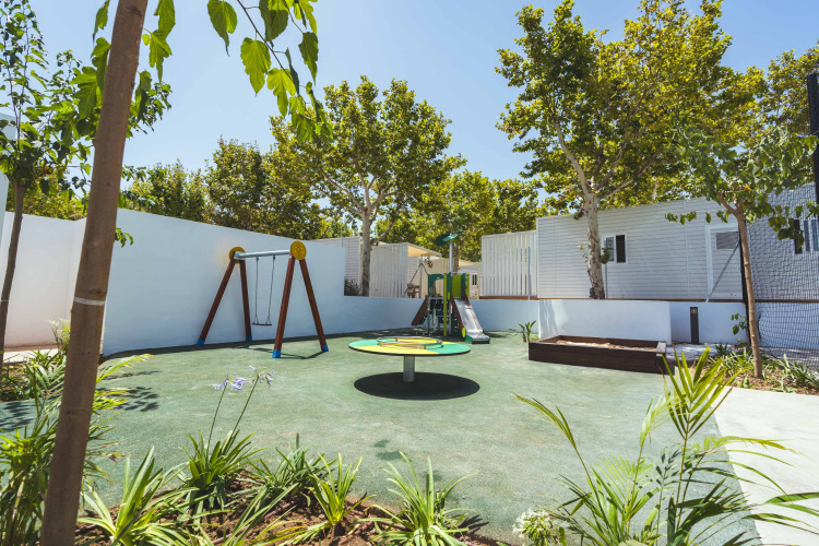 Kinderspielplatz mit Schaukeln, Rutsche und Karussell bei Camping Costa del Sol Glamping Village in Andalusien.