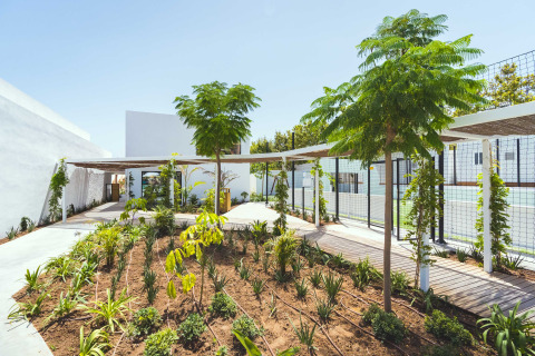 Landscaped garden with trees and shaded walkway at Camping Costa del Sol Glamping Village in Andalusia, Spain.