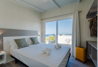 Chambre moderne avec lit double au Bungalow Leo Sea View, vue sur la mer, à Camping Costa del Sol.