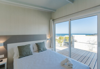 Dormitorio luminoso en el Bungalow Leo Sea View con vistas al mar, Camping Costa del Sol Glamping Village, España.