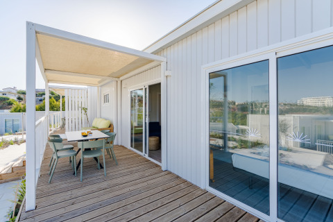 Terraza exterior con zona de comedor y vistas al mar en Bungalow Leo Sea View, Camping Costa del Sol Glamping Village.