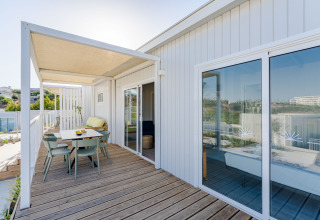 Terraza exterior con zona de comedor y vistas al mar en Bungalow Leo Sea View, Camping Costa del Sol Glamping Village.