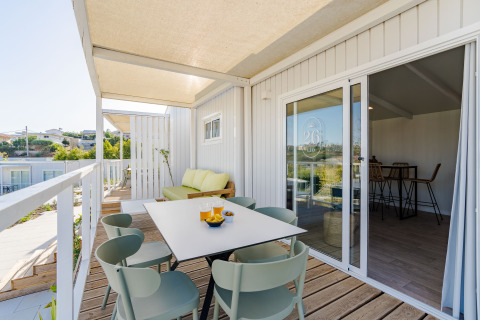 Terrazza con tavolo da pranzo e divano al Bungalow Leo Sea View, Camping Costa del Sol Glamping Village, Spagna.