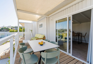 Terrazza con tavolo da pranzo e divano al Bungalow Leo Sea View, Camping Costa del Sol Glamping Village, Spagna.