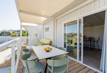 Terrazza con tavolo da pranzo e divano al Bungalow Leo Sea View, Camping Costa del Sol Glamping Village, Spagna.