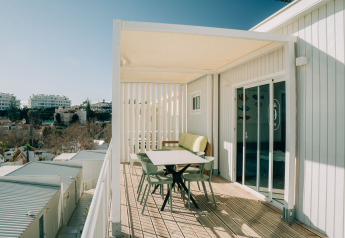 Balcone soleggiato del Bungalow Leo Sea View al Camping Costa del Sol Glamping Village con vista sulla città.