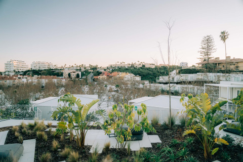 Aussicht auf moderne Bungalows und Palmen im Camping Costa del Sol Glamping Village, Spanien, bei Sonnenuntergang.