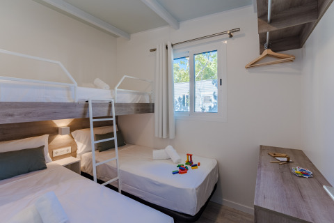 Foto eines modernen Lodge-Zimmers mit Etagenbett, Einzelbetten, Spielzeug, Fenster und Holzmöbeln.