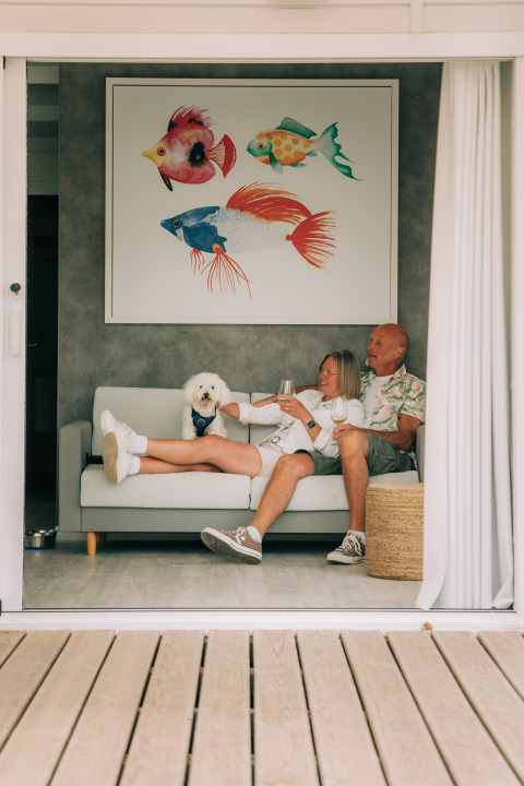 Pareja relajándose con su perro y vino en Bungalow Neri de Camping Costa del Sol Glamping Village, España.