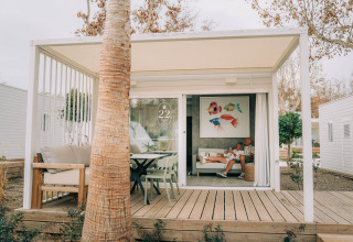 Bungalow Neri Pet Friendly en Camping Costa del Sol Glamping Village, España, con personas relajándose dentro.