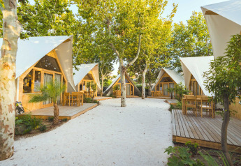 Moderne houten lodges met terrassen tussen bomen bij Camping Costa del Sol Glamping Village in Spanje.
