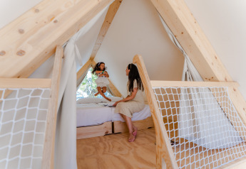 Madre e figlia giocano nel lodge triangolare Hanna al Camping Costa del Sol Glamping Village in Spagna.