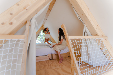 Mutter und Tochter spielen in einer A-Rahmen-Lodge namens Hanna im Camping Costa del Sol Glamping Village, Spanien.