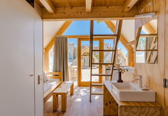 Interieur van een houten lodge met slaapzolder en grote glazen deur bij Hanna, Camping Costa del Sol Glamping Village, Spanje.