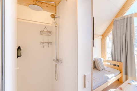 Lichte douche en knusse slaapkamer in de Hanna-lodge bij Camping Costa del Sol Glamping Village in Spanje.