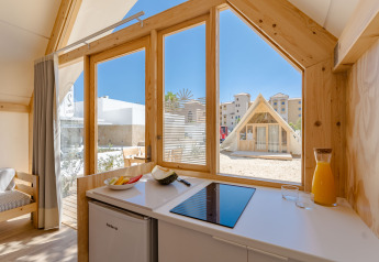Interior view of Hanna lodge at Camping Costa del Sol Glamping Village in Spain, showing kitchen and outside.