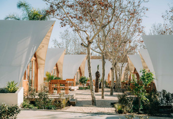 Tende glamping moderne con aree esterne sotto gli alberi a Hanna presso Camping Costa del Sol Glamping Village, Spagna.